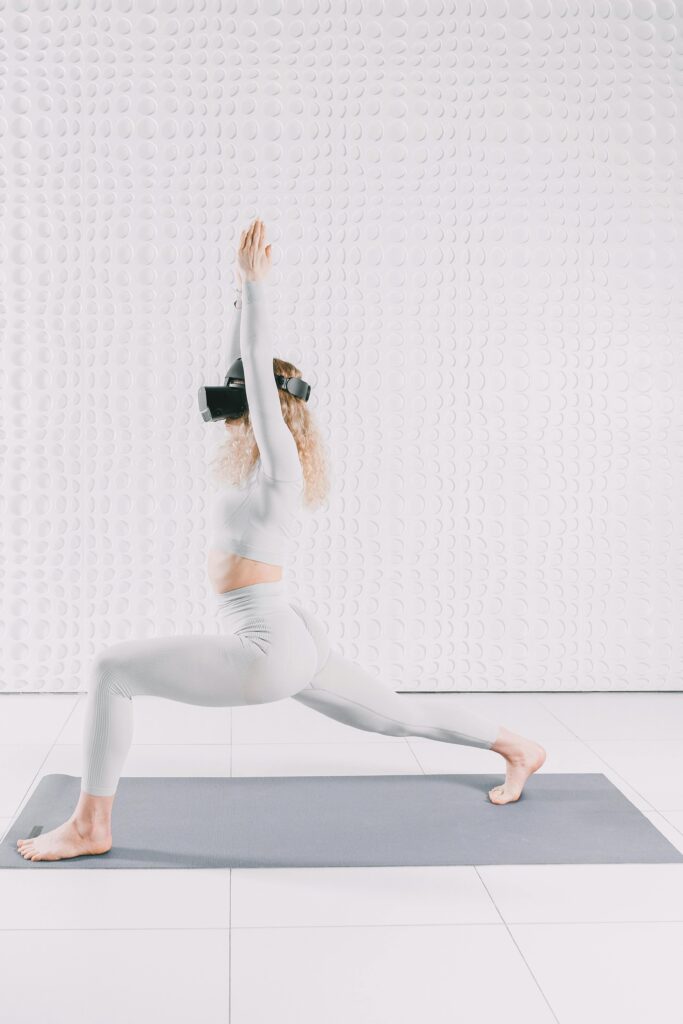 A woman practicing yoga indoors using a VR headset, embracing technology and fitness.